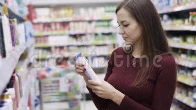 有魅力的女人在超市里拿着<strong>沐浴露</strong>闻闻，情绪喜欢和不喜欢